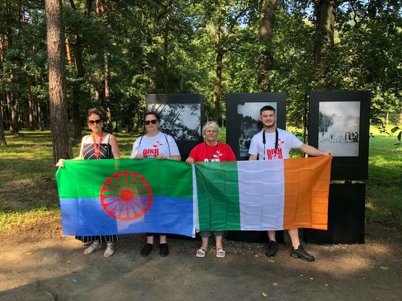 3 women standing with Roma flag and Irish flag 
