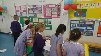 Children looking at photos of caravans and wagons 