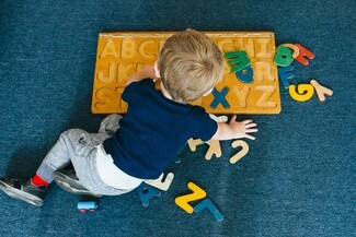 Small boy playing with an alphabet puzzle