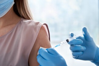 Woman being injected with a needle by a nurse vaccine