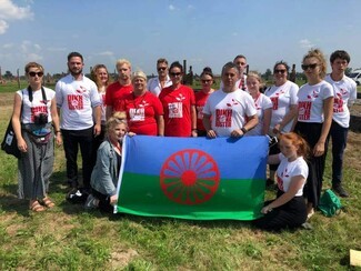 Young people with Roma flak in Auschwitz-Birkenau