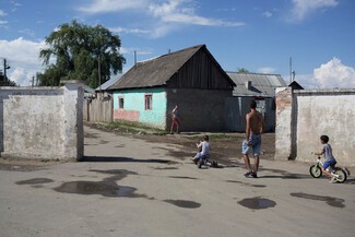 © Alex Sturrock 2018. The Roma-only settlement in Beregovo where many Roma have returned after a spate of far-right attacks. Separated from the rest of the town by a segregation wall, most of the homes have no access to running water or electricity and are without housing agreements to protect the rights of the occupants. Lack of documentation holds back many people here from accessing public services and official employment.