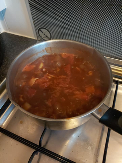 A traditional one pot 'Joe Grey' stew on the go - tomatoes, stock cubes, water, onion, sausage and lots of bacon and potatoes. From Pheobe L Stevens