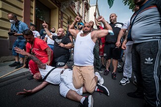 In Teplice, Roma campaigners re-enact the death of Stanislav Tomas in front of ranks of riot police © Petr Zewlakk Vrabec