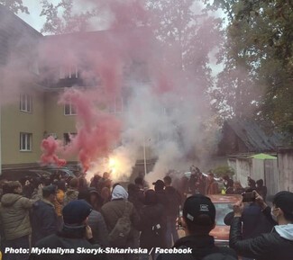 A far-right mob advance on a Roma settlement near Kyiv in 2021 before being held back by lines of Ukrainian police