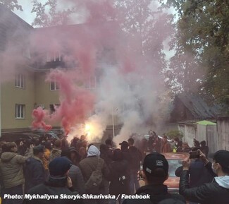 A far-right mob advance on a Roma settlement near Kyiv in 2021 before being held back by lines of Ukrainian police