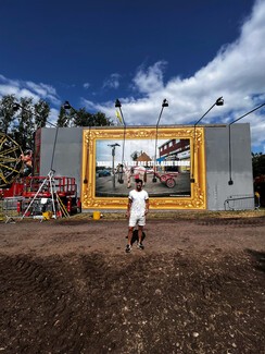 Billboard in progress, with Roma man in white standing in front