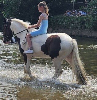 Touched by the sight of Piper Ann riding her hobby horse into the River Eden, generous fellow fair-goer then let Piper Ann ride one of their horses into the river © Deborah Stocks