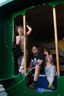 Caption: Brothers Oliver, Henley and Archie suck on lollipops as they peer out of their Bow Top wagon in Middleham June 1, 2024 © Georger Norris