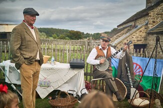 Prominent Romany Gypsy campaigner, Romany representative on the Appleby Fair organising committee and Shera Rom looks on as musician Bill Lloyd plays. The flag in the background is the International Romani flag