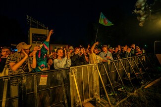 amber light shines on young crowd dancing to concert.